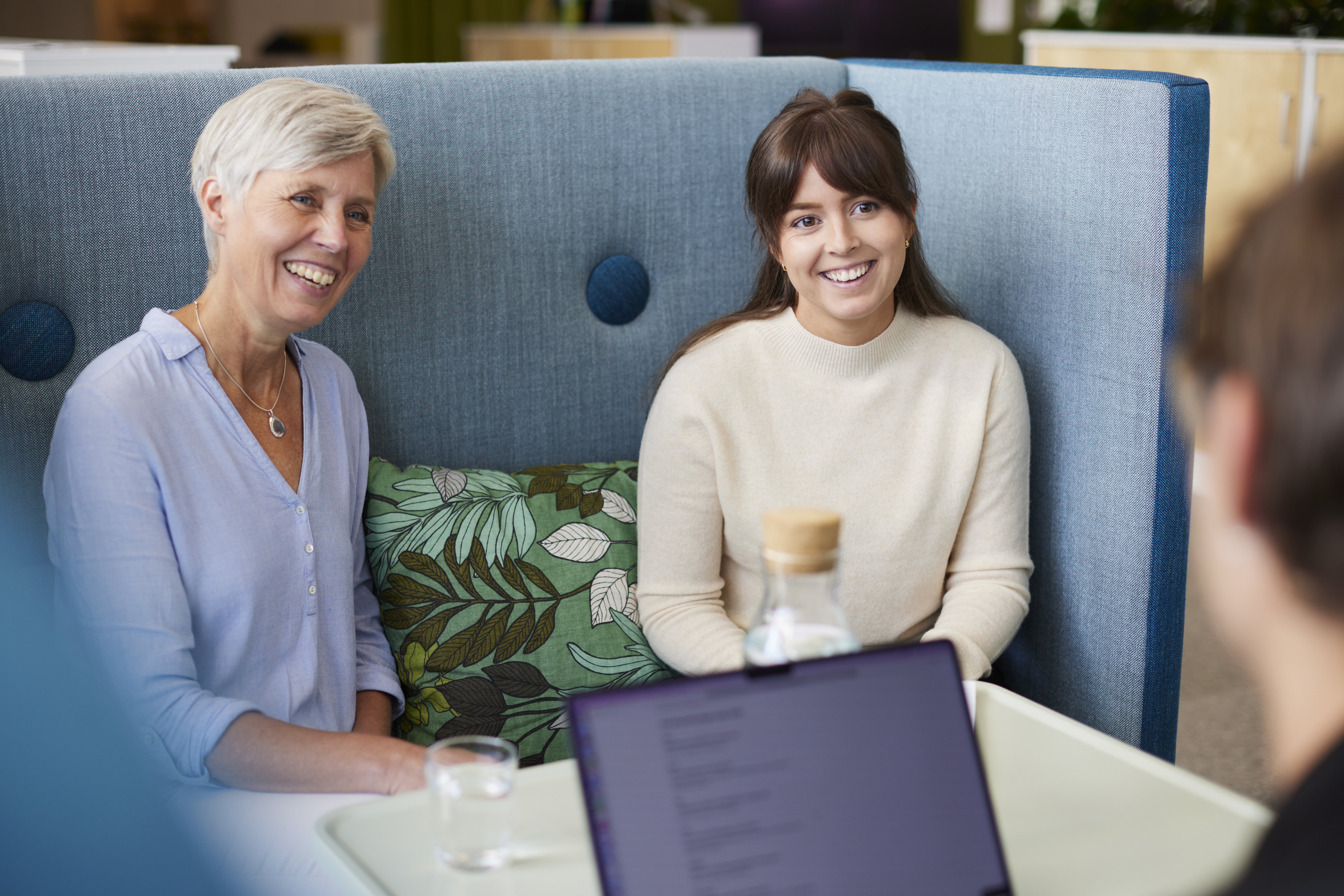 Tre glada personer i kontorslandskap