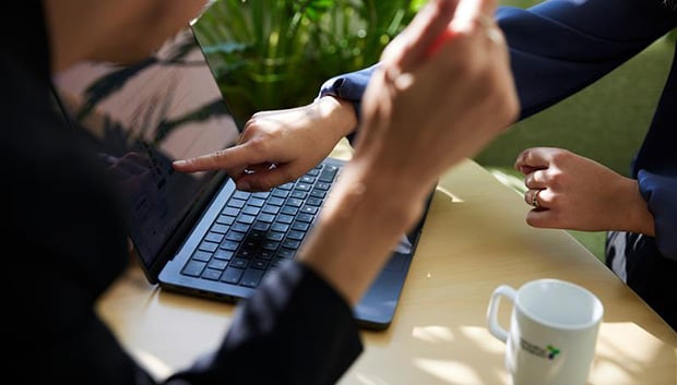 Händer håller mugg med Upphandlingsmyndighetens logotyp